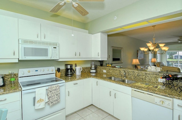 kitchen featuring dark stone countertops, sink, white cabinets, and white appliances