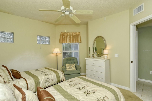 tiled bedroom featuring a textured ceiling and ceiling fan