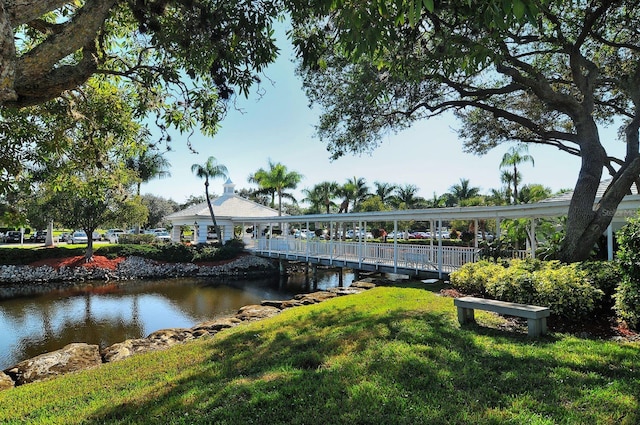 view of dock featuring a lawn and a water view