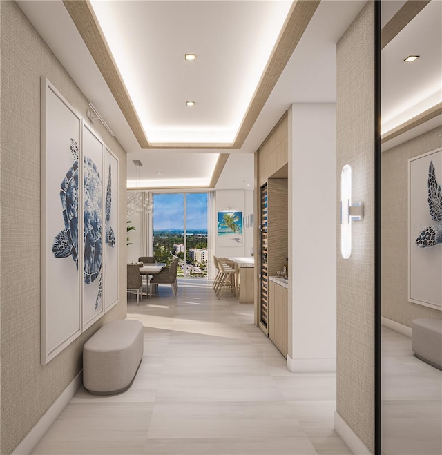 hallway with floor to ceiling windows and a tray ceiling