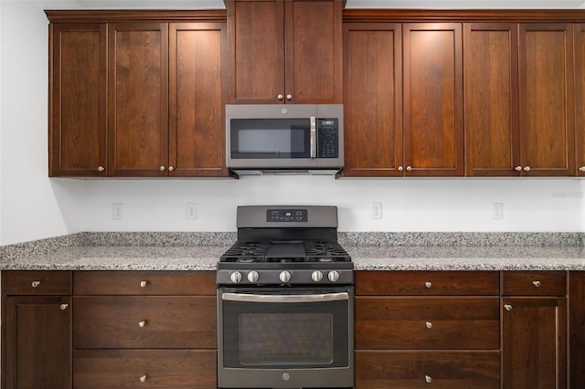 kitchen with light stone countertops and stainless steel appliances