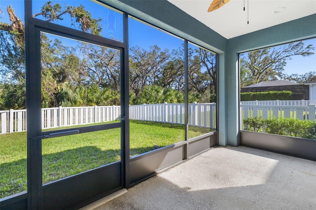 unfurnished sunroom featuring ceiling fan