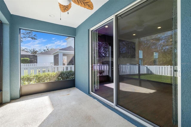 unfurnished sunroom featuring ceiling fan and a wealth of natural light