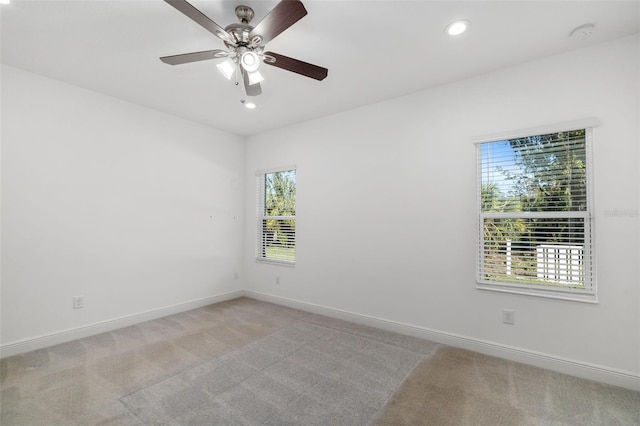 carpeted spare room with plenty of natural light and ceiling fan