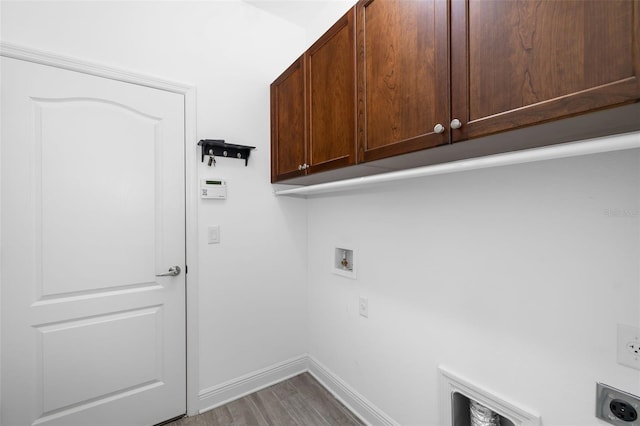 clothes washing area featuring electric dryer hookup, hookup for a washing machine, cabinets, and wood-type flooring