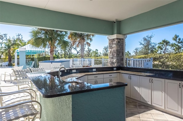 view of patio featuring a gazebo, an outdoor kitchen, and a wet bar