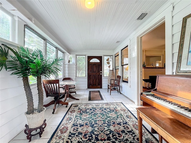 entrance foyer with wood ceiling, light tile patterned floors, and wooden walls