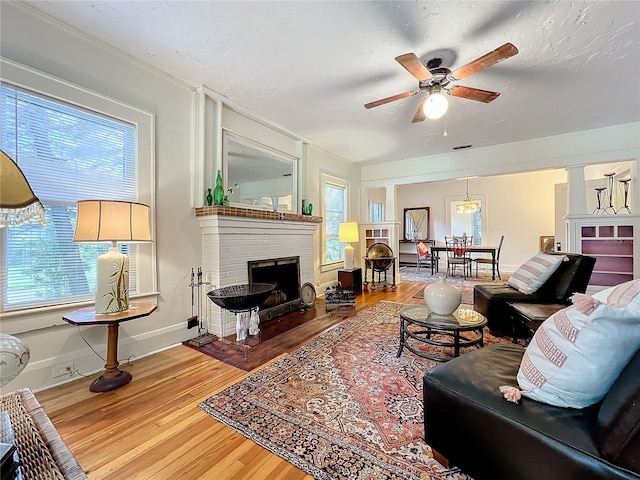 living room featuring plenty of natural light, ceiling fan, wood-type flooring, and a fireplace