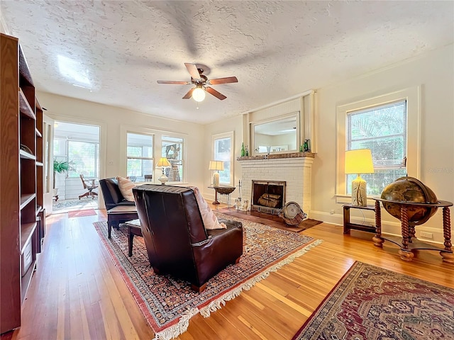 living room featuring a wealth of natural light, wood-type flooring, and a textured ceiling