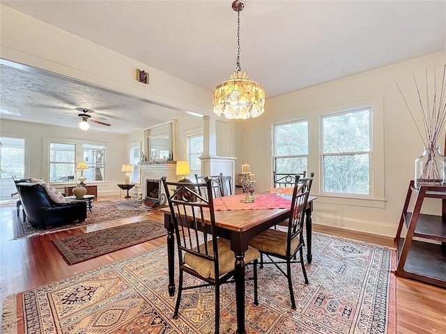 dining area with hardwood / wood-style flooring, ceiling fan, a healthy amount of sunlight, and decorative columns