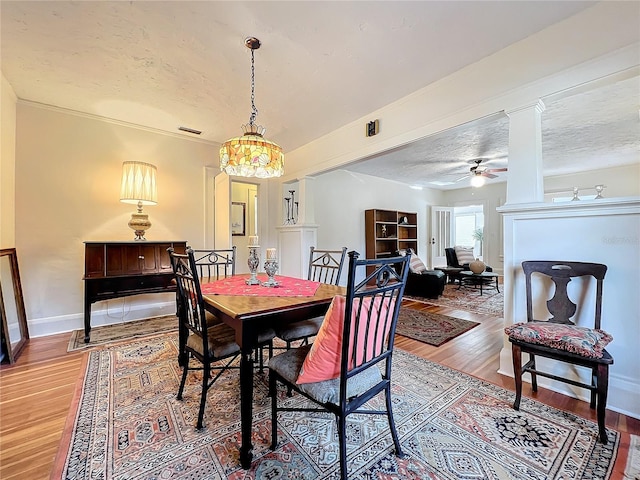 dining area with a textured ceiling, hardwood / wood-style flooring, ceiling fan, and crown molding