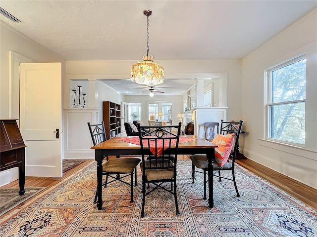 dining room with wood-type flooring, ceiling fan, and a healthy amount of sunlight