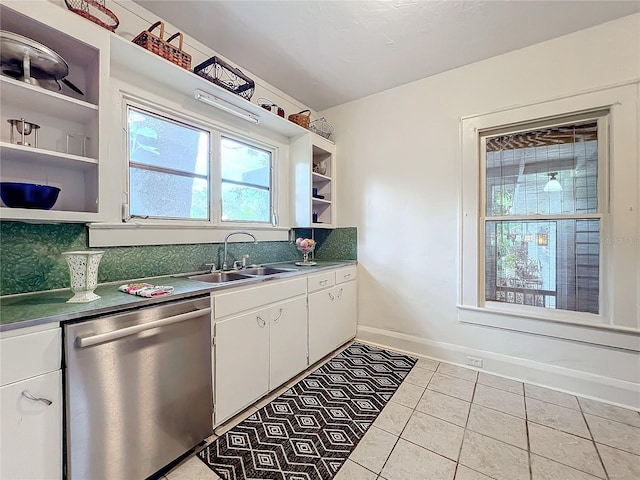 kitchen with stainless steel dishwasher, light tile patterned flooring, white cabinetry, and sink