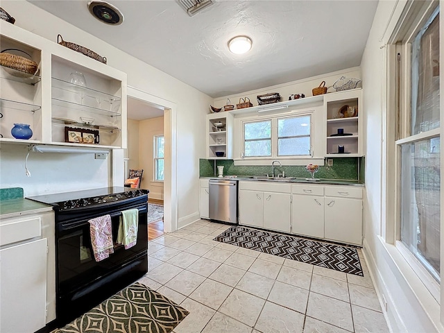 kitchen with stainless steel dishwasher, sink, light tile patterned floors, electric range, and white cabinets