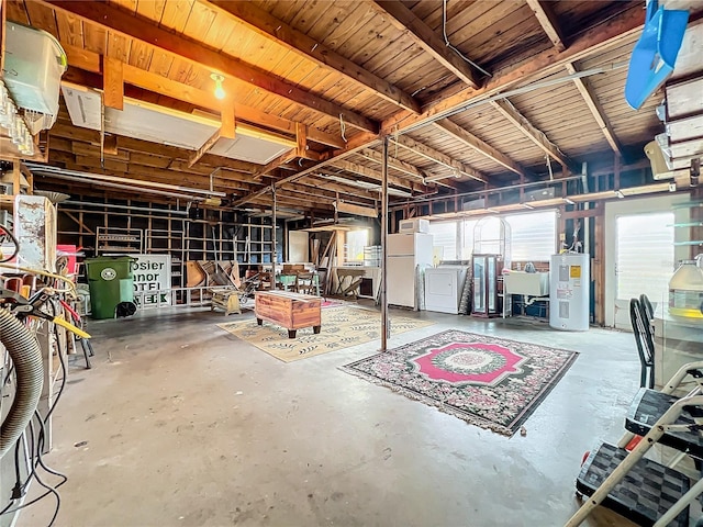 garage featuring washer / dryer, electric water heater, sink, and white refrigerator