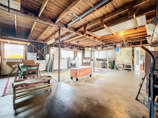 basement featuring washing machine and dryer, a workshop area, and white refrigerator