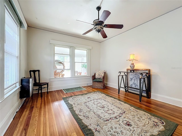 living area with hardwood / wood-style floors and ceiling fan