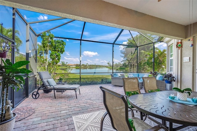 view of patio with a water view and glass enclosure