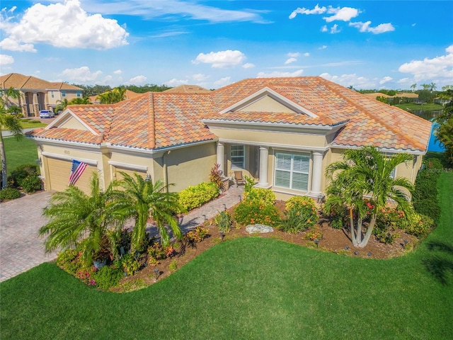 mediterranean / spanish house featuring a garage and a front lawn