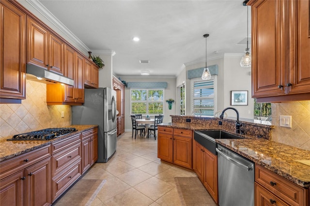 kitchen featuring sink, stainless steel appliances, dark stone counters, decorative light fixtures, and ornamental molding