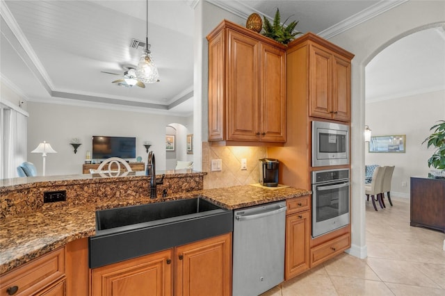 kitchen featuring ceiling fan, sink, dark stone counters, decorative backsplash, and appliances with stainless steel finishes