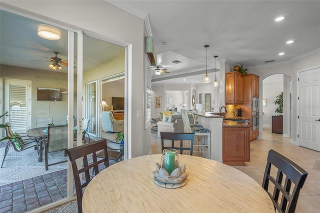 tiled dining room featuring crown molding and ceiling fan