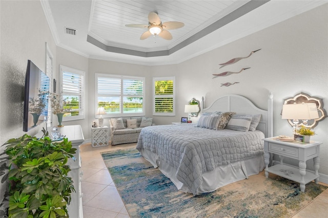 bedroom with ceiling fan, a raised ceiling, ornamental molding, and light tile patterned floors