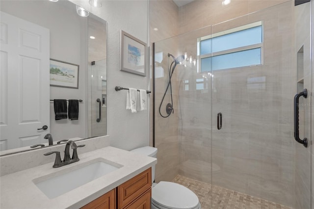 bathroom featuring vanity, toilet, and an enclosed shower