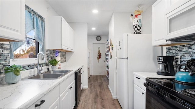 kitchen featuring tasteful backsplash, sink, black appliances, light hardwood / wood-style flooring, and white cabinetry