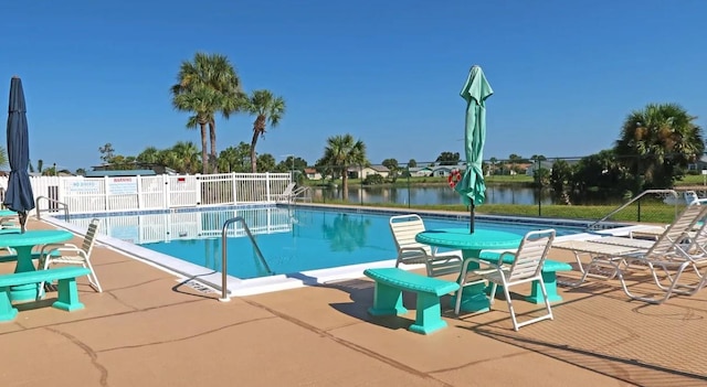 view of pool with a water view and a patio