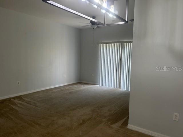 carpeted spare room featuring ceiling fan