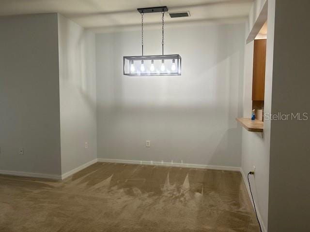 unfurnished dining area featuring carpet flooring