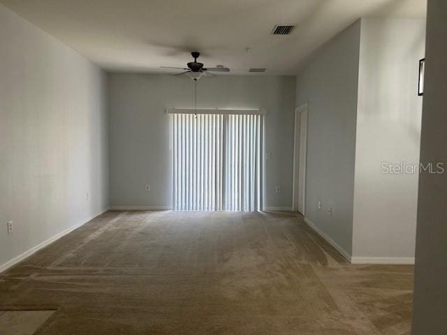 carpeted spare room with ceiling fan