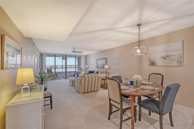 dining area with light carpet, expansive windows, and ceiling fan