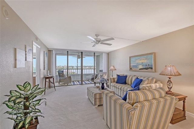 carpeted living room with ceiling fan and expansive windows