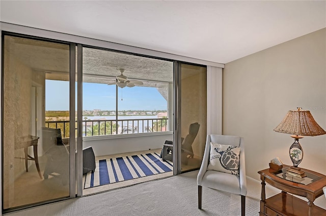 5911 Midnight Pass Rd Unit 504, Sarasota, FL 34242 - sitting room featuring carpet flooring, a ceiling fan, and a water view