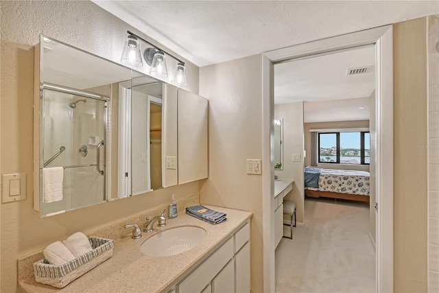 bathroom with vanity and a shower with door