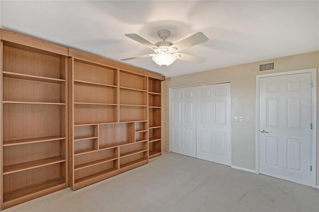 unfurnished bedroom featuring ceiling fan, a closet, and light colored carpet