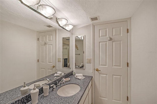 bathroom with vanity and a textured ceiling