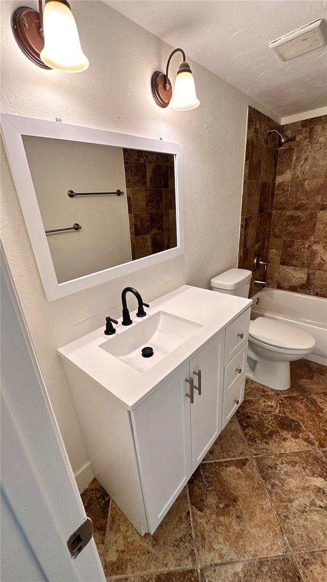 full bathroom with vanity, toilet, and tiled shower / bath