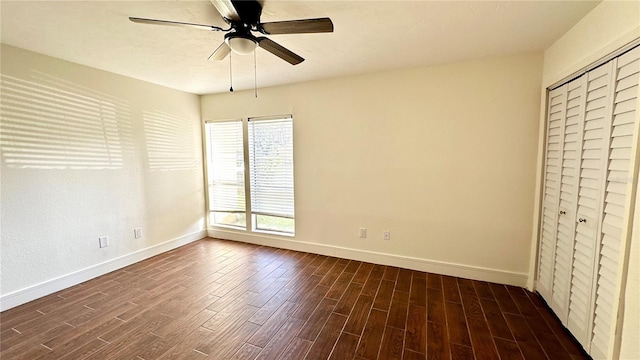 unfurnished bedroom with ceiling fan, dark wood-type flooring, and a closet