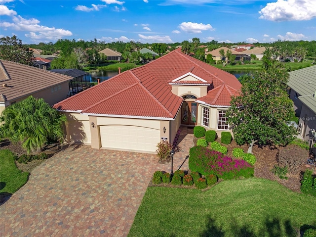 view of front of house featuring a front yard, a garage, and a water view