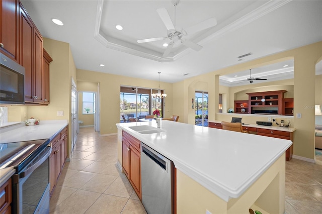 kitchen with sink, crown molding, a center island with sink, a raised ceiling, and dishwasher