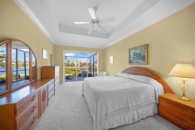 bedroom featuring access to outside, light colored carpet, ceiling fan, and a tray ceiling