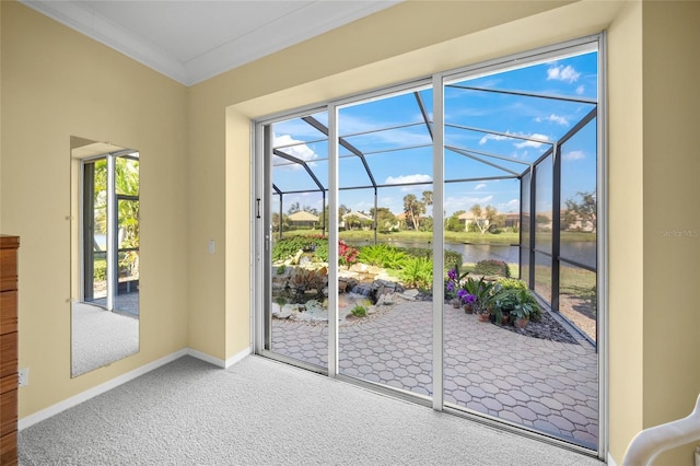 doorway to outside with a water view, ornamental molding, and carpet