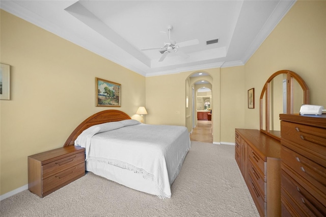 bedroom featuring a raised ceiling, crown molding, light colored carpet, and ceiling fan