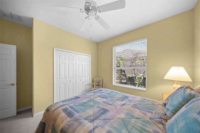 carpeted bedroom with ceiling fan and a closet