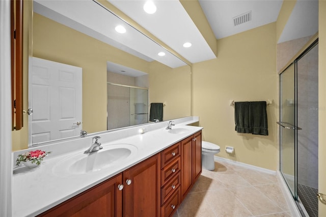 bathroom featuring vanity, a shower with shower door, tile patterned floors, and toilet