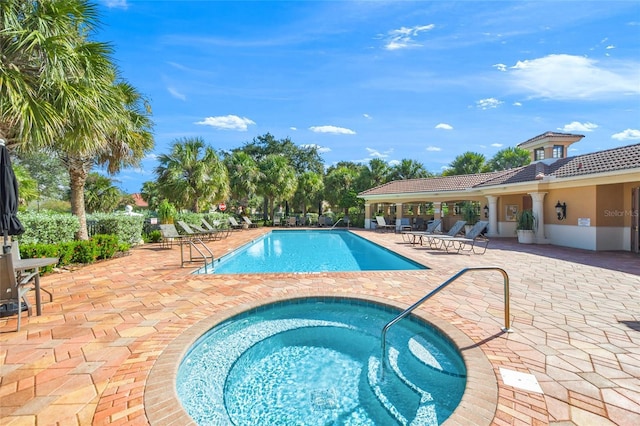 view of pool with a community hot tub and a patio area