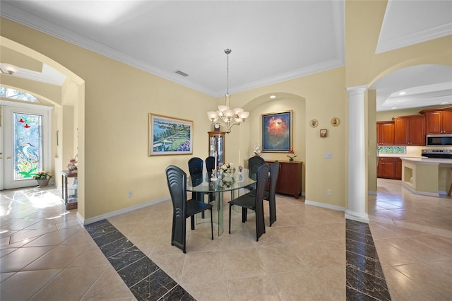 dining area with crown molding, a chandelier, and ornate columns